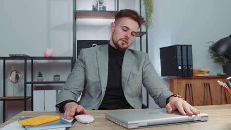 Business-smiling-man-closing-laptop-computer-after-finishing-online-work-remote-job-from-home-office