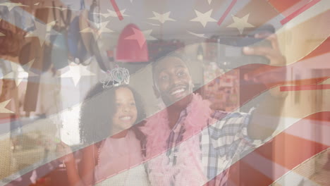 animation of flag of united states of america over african american father and daughter having fun