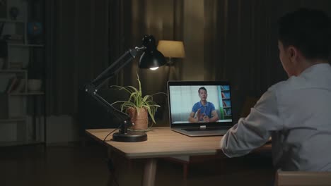 man in video conference call at night