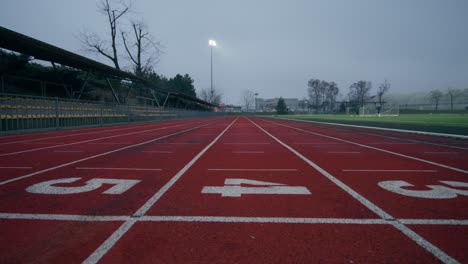 empty running track at a sports complex on a cloudy day