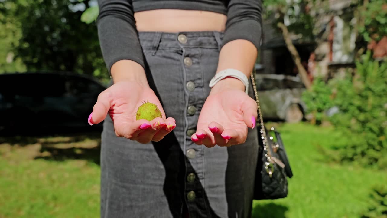 Slow motion close up of woman rolling chestnut in sunlight with gentle movement