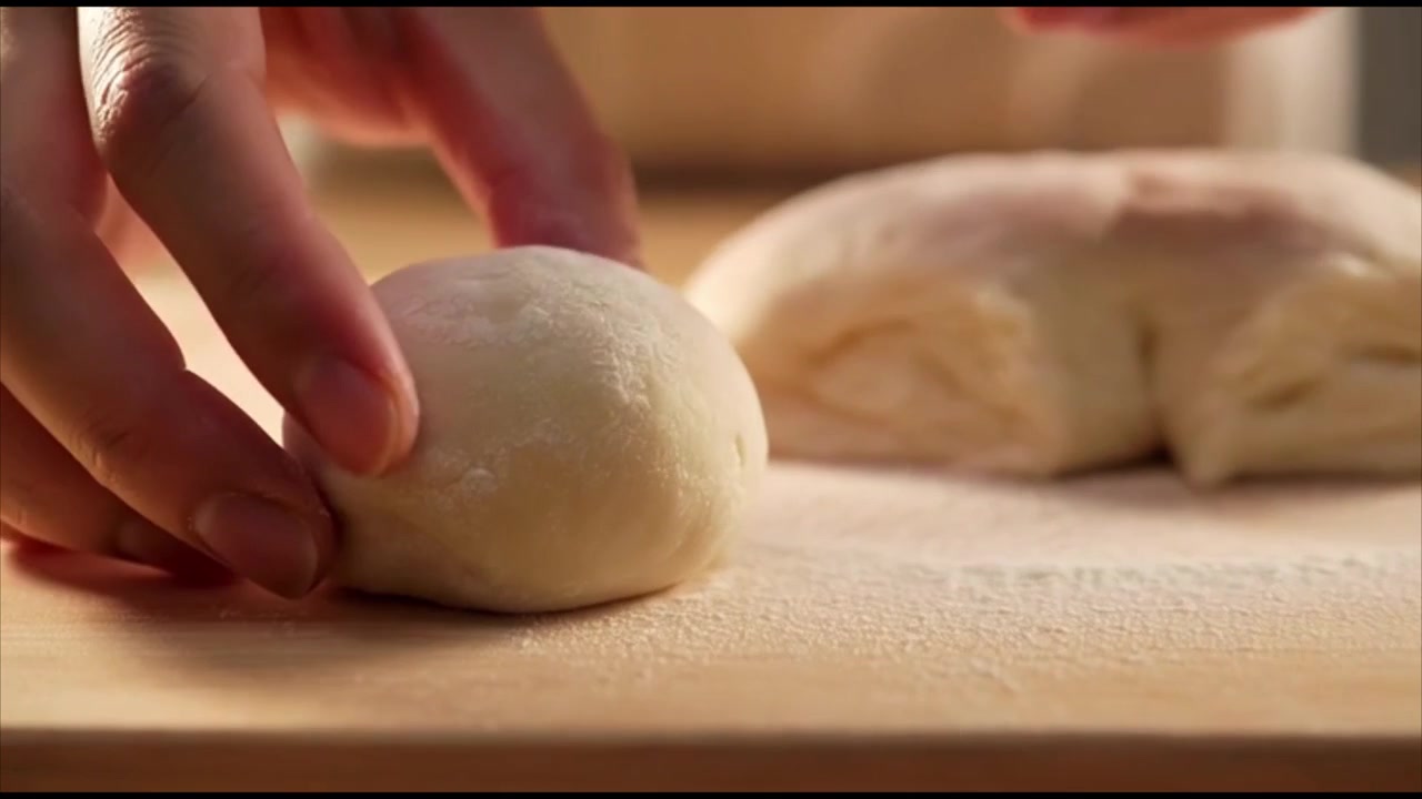 Baker Shaping Fresh Dough Balls on a Wooden Board