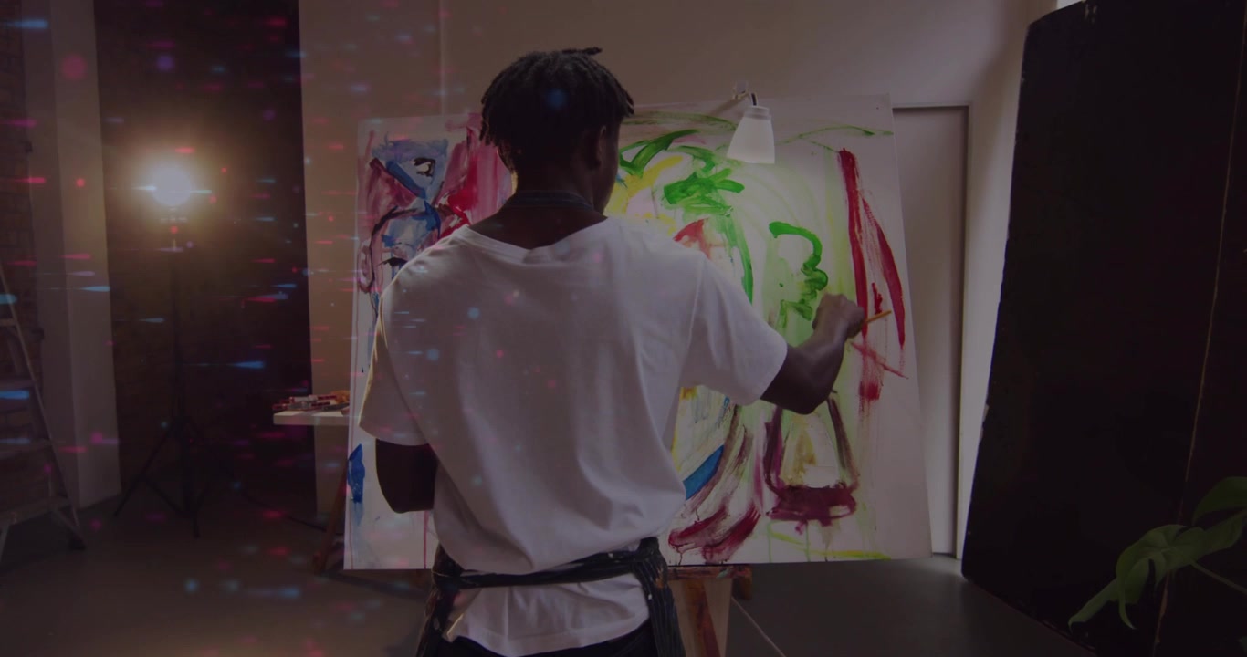 Painting painter in apron seeing broad marks, applying red strokes on easel with brush in studio