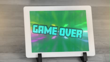 digital animation of game over text against glowing tunnel on screen of digital tablet on wooden sur