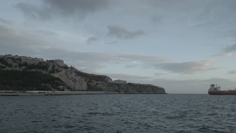 A-4K-panning-shot-over-the-sea-in-the-straits-of-Gibraltar,-panning-from-Algeciras-Spain,-looking-past-Africa-and-over-to-Rosia-Bay-in-Gibraltar-on-a-cloudy-day