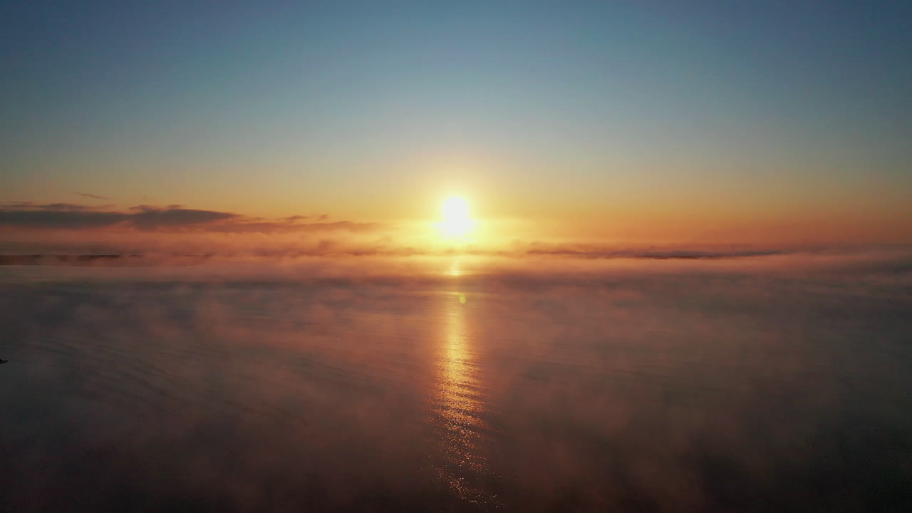 Drone Flying Towards The Golden Sun Over The Foggy Lake In South Iceland. - aerial drone shot