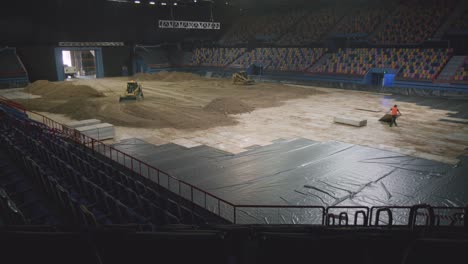 machines pushing dirt inside large stadium