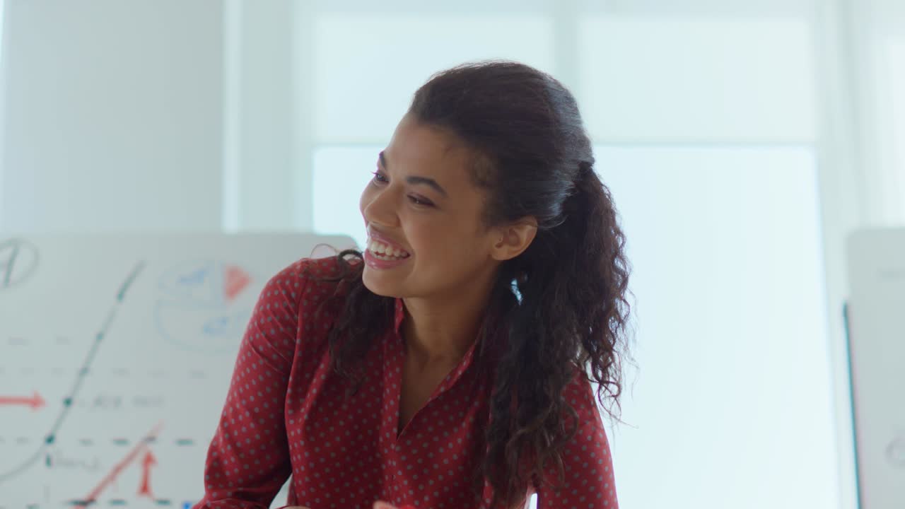 Smiling afro businesswoman thinking in modern office