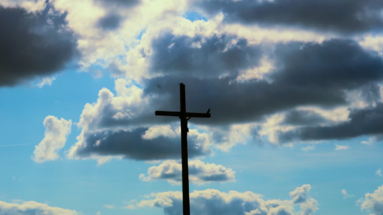 Symbolic Christian Jesus Christ Cross Silhouette with Dynamic Dark Clouds in Background Signifying Heaven, God and Holy Resurrection 4K