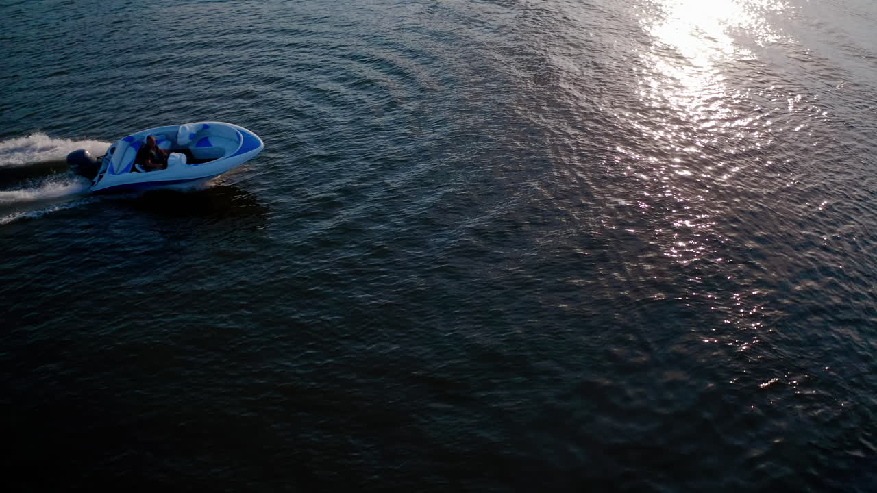 Motoscafo galleggia sul fiume. Drone che vola sopra il fiume con un motoscafo che sfreccia.