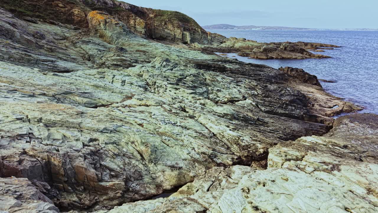 Scenic aerial view of rocky coastline meeting calm waters