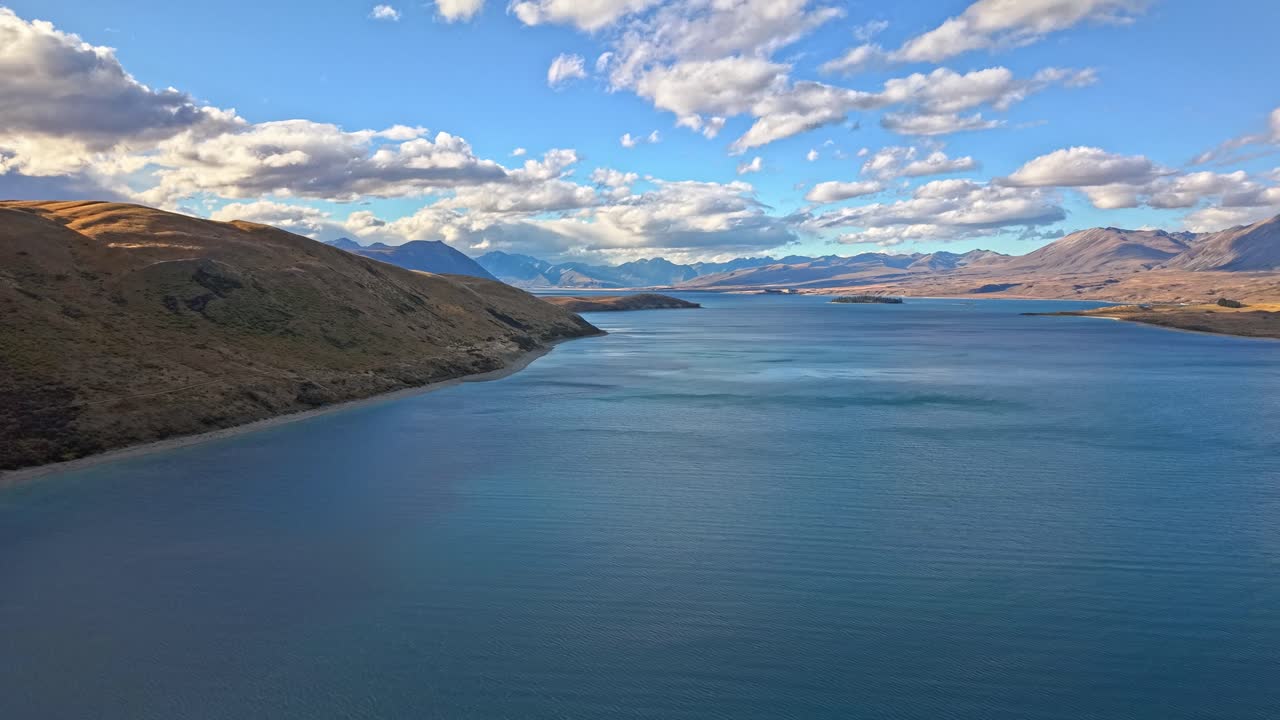 Tekapo Lake's blue hues and alpine views on a sunny day in New Zealand