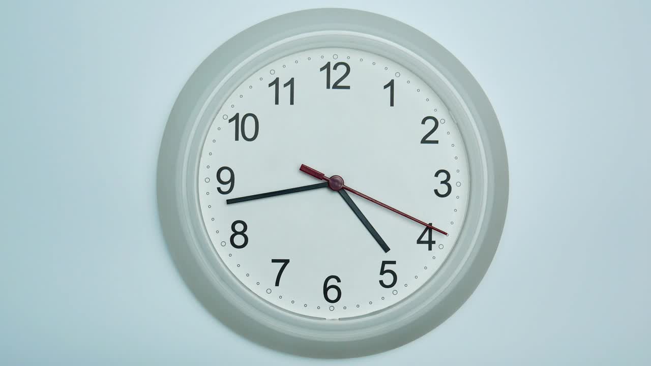 Orologio da parete bianco che mostra le cinque meno venti.