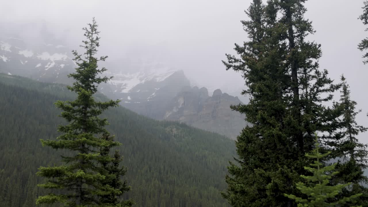 View of the mountain range surrounding Moraine Lake in Banff National Park Alberta on a slightly foggy afternoon.