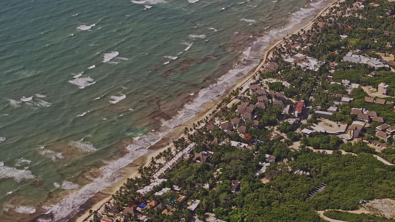 tulum méxico aerial v22 zoom birds eye view drone flyover ciudad turística a lo largo de la playa de arena de la costa del caribe capturando olas tranquilas que se estrellan contra la orilla - filmado con mavic 3 pro cine - julio 2023