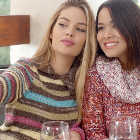 two pretty girls taking selfie at the cafe