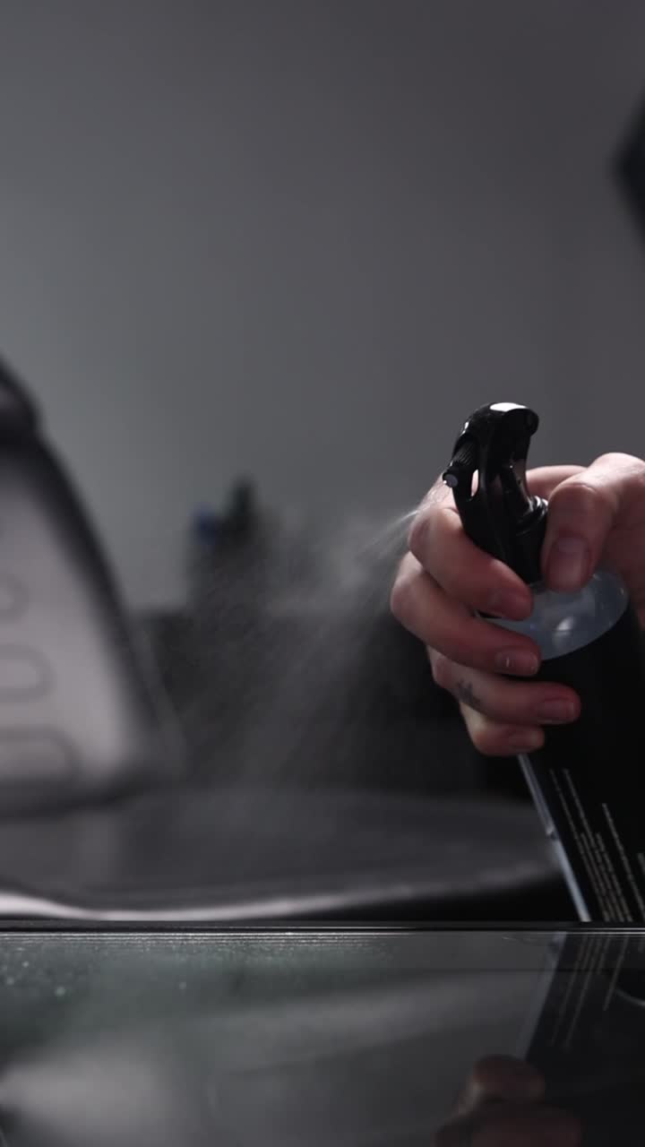 Hand Spraying Cleaning Liquid from a Bottle