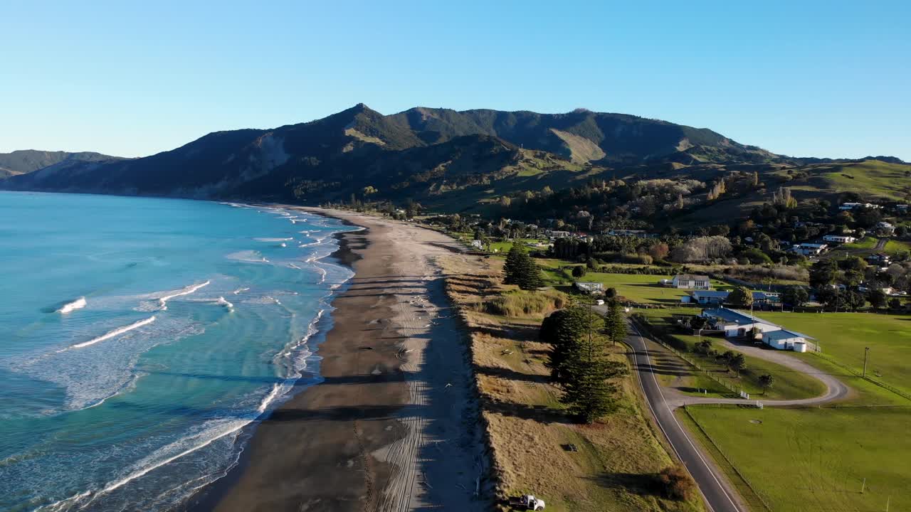 놀라운 모래 해변, 조용한 파란 바다, 지평선에 있는 언덕의 조류의 시야