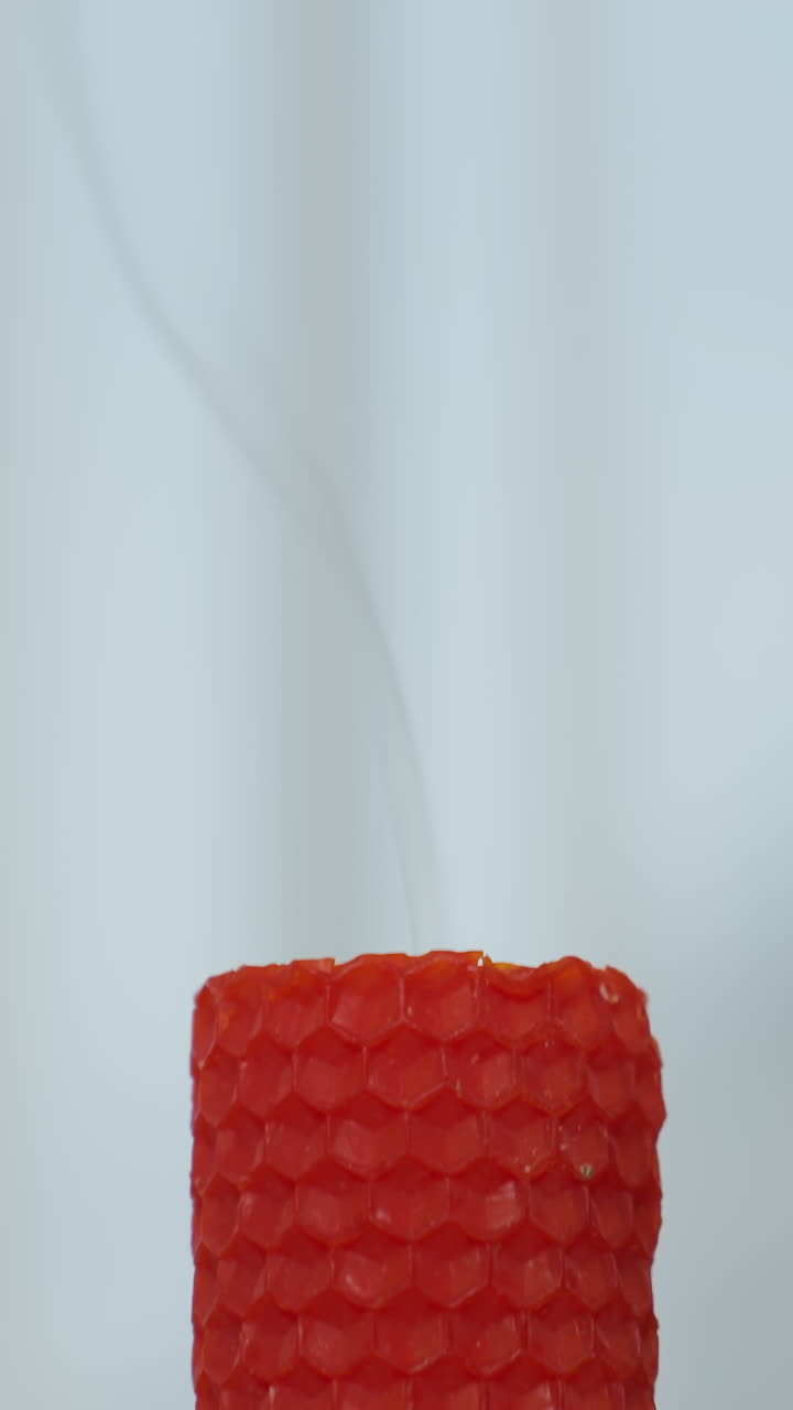 은 불이 꺼진 후 미세한 연기를 방출하는 클로즈업, 부드러운 색 커튼과 배경에 흐릿한 인물