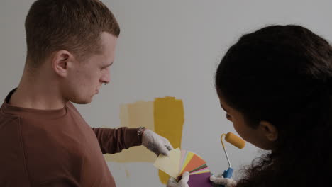 young couple choosing paint colors for home renovation