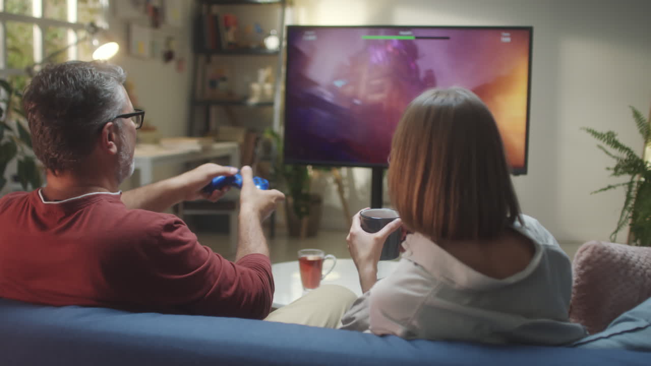 Couple playing video games together in a living room