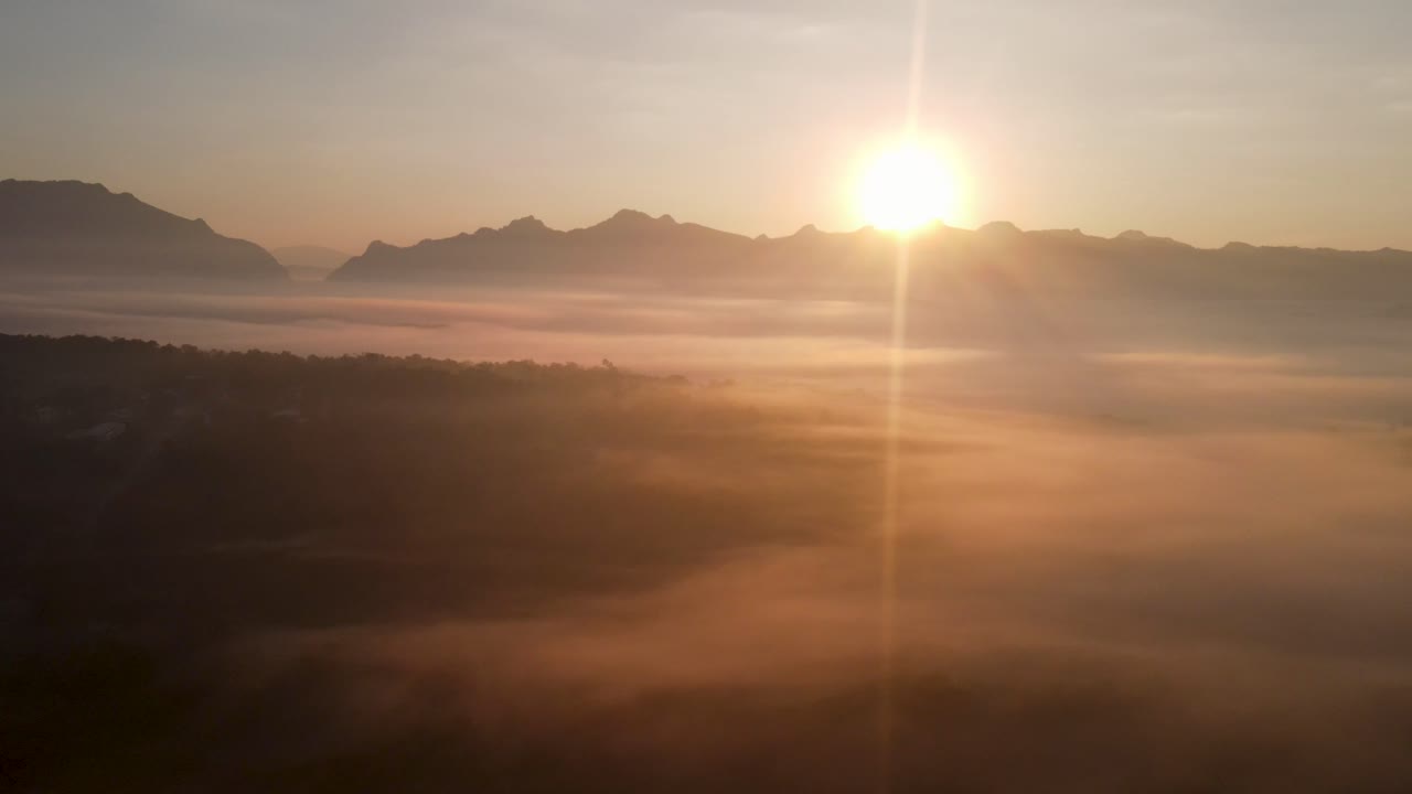 drone aéreo de puesta de sol brillando en la montaña doi luang chiang dao con niebla