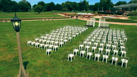 antena dando vueltas sobre la boda con sillas blancas y un elegante arco en el conservatorio del parque garfield de indianapolis, indiana