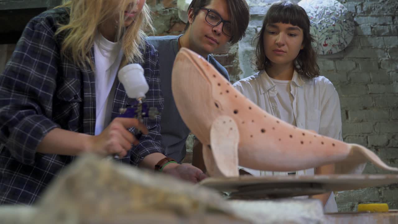 학생 들 이 미술 스튜디오 에서 점토 고래 조각 을 그린다