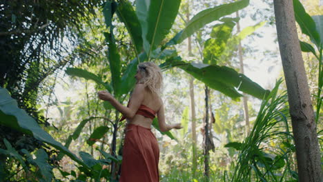 mujer feliz bailando en el bosque disfrutando de la naturaleza bailando en la exuberante jungla tropical 4k