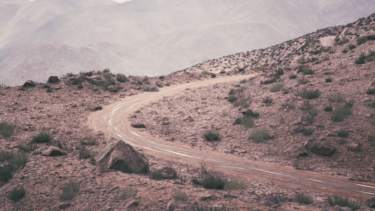 camino de tierra sinuoso a través de las montañas del desierto