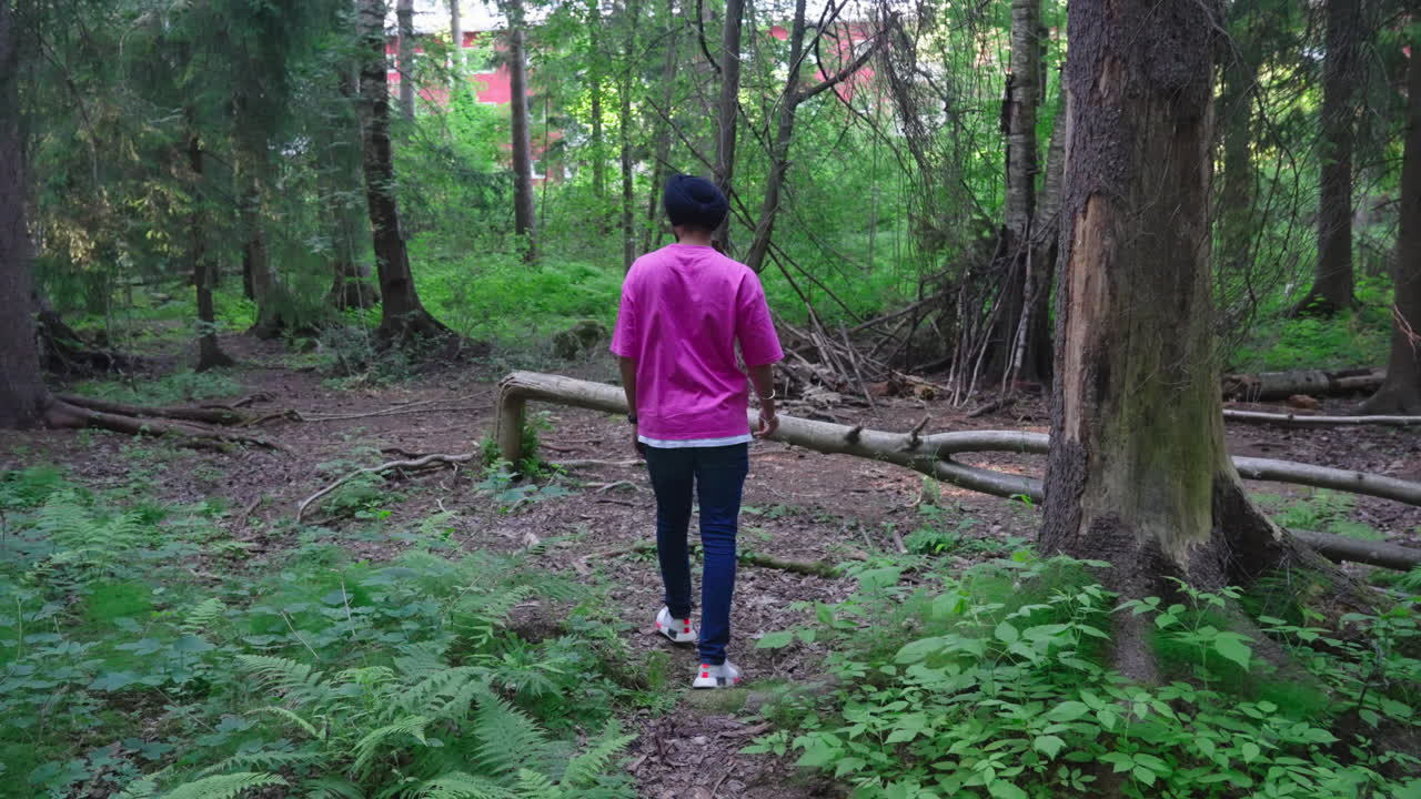 고사리 식물과 함께 숲에서 걷는 인도 펀잡 시크교 남자