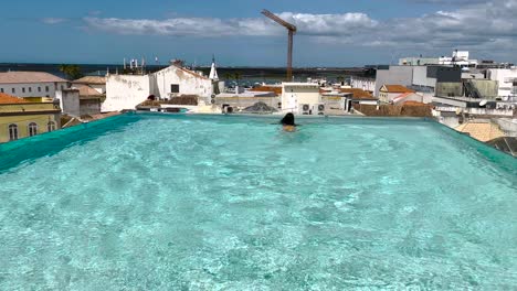 brunette woman swims in an urban hot water pool during the summer