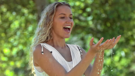 blonde woman in slow motion catching water