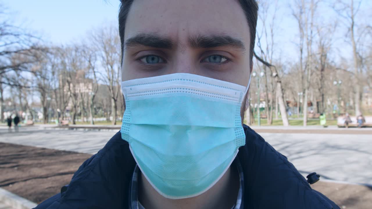 un hombre con una máscara en un parque.