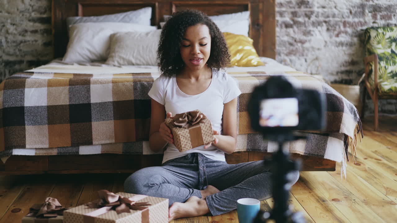 Young woman unboxing a gift in her bedroom