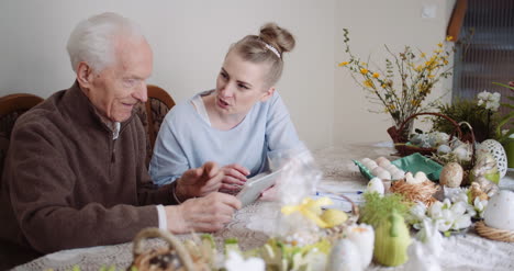 granddaughter with grandfather using digital tablet 6