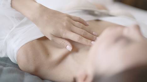 woman lying down, touching her chest