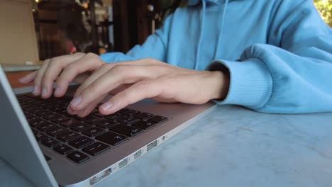 hands on keyboard close up. girl working office work remotely at the cafe, woman using laptop computer distance learning online education and work