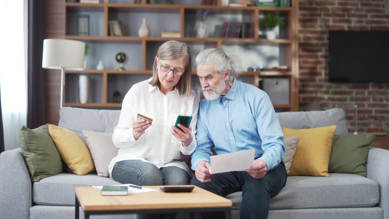 coppia familiare anziana, vecchio uomo e donna dai capelli grigi pagano per i servizi inseriscono i documenti di dati utilizzando l'applicazione smartphone mobile
