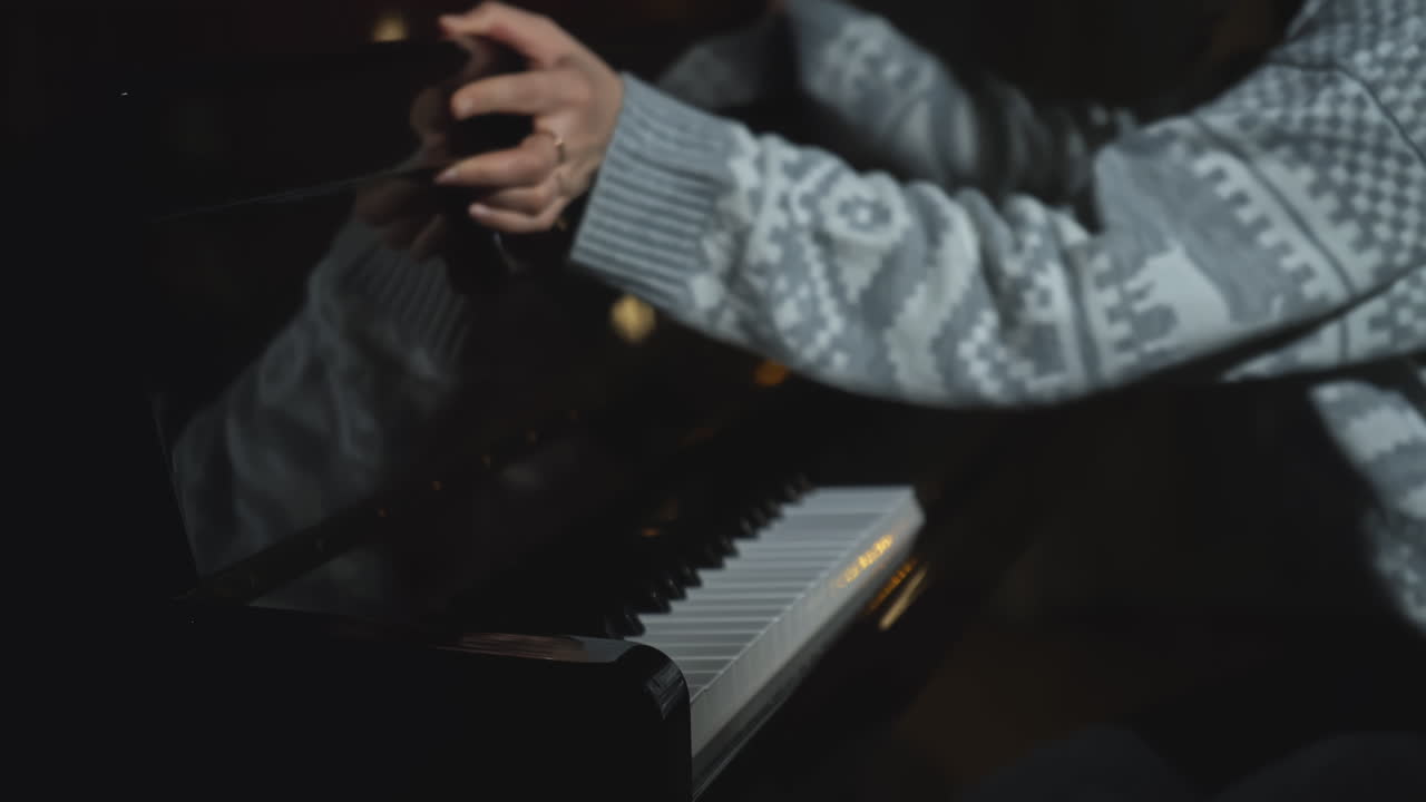 어두운 방에서 피아노를 연주하는 여자