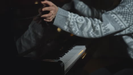 woman playing piano in a dark room