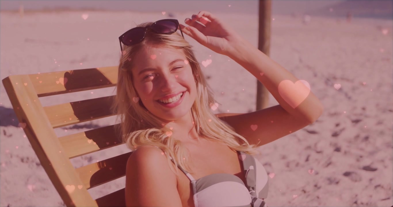 Sovrapposizioni a cuore che scorrono sulla spiaggia, donna seduta su una sedia a sdraio che si sistema gli occhiali da sole per marketing.