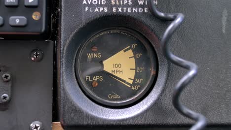 airplane cockpit wing flaps position indicator moving up - close up