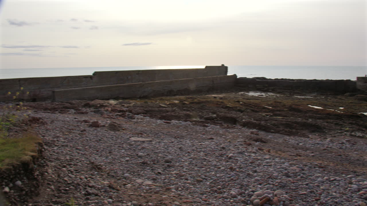 Wide panning shot of the old harbour and beach at Auchmithie, Arbroath