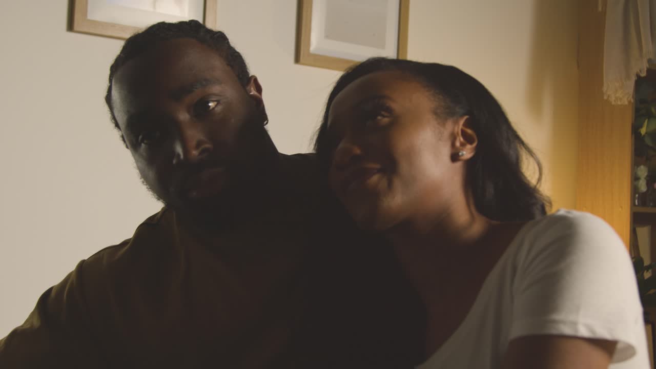 pareja de amor relajándose en casa sentados en la cama por la noche hablando juntos