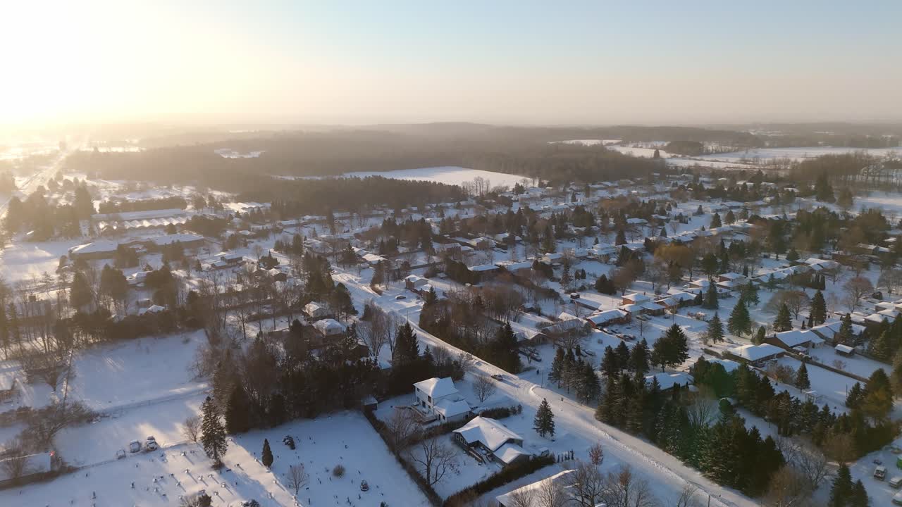 Sunrise Over Homes In The Town Of Alton In Caledon, Ontario During Winter. Aerial Flyover.