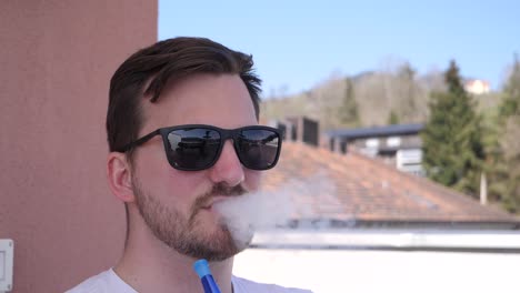 Good-looking-European-with-sunglasses-blows-hookah-smoke-out-in-slow-motion