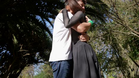 una pareja abrazándose en un parque.