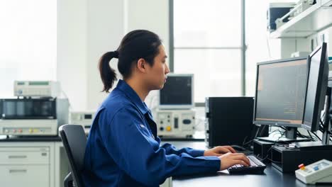 focused researcher engaging in data analysis at a modern laboratory, attentively working with advanced computer technology and equipment