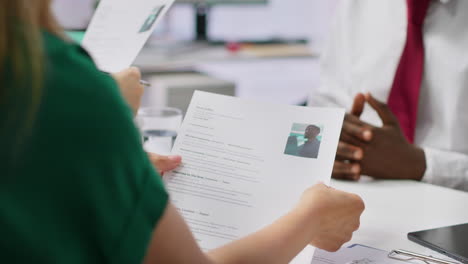 job candidate hands over his cv to team of hr professionals to start interview